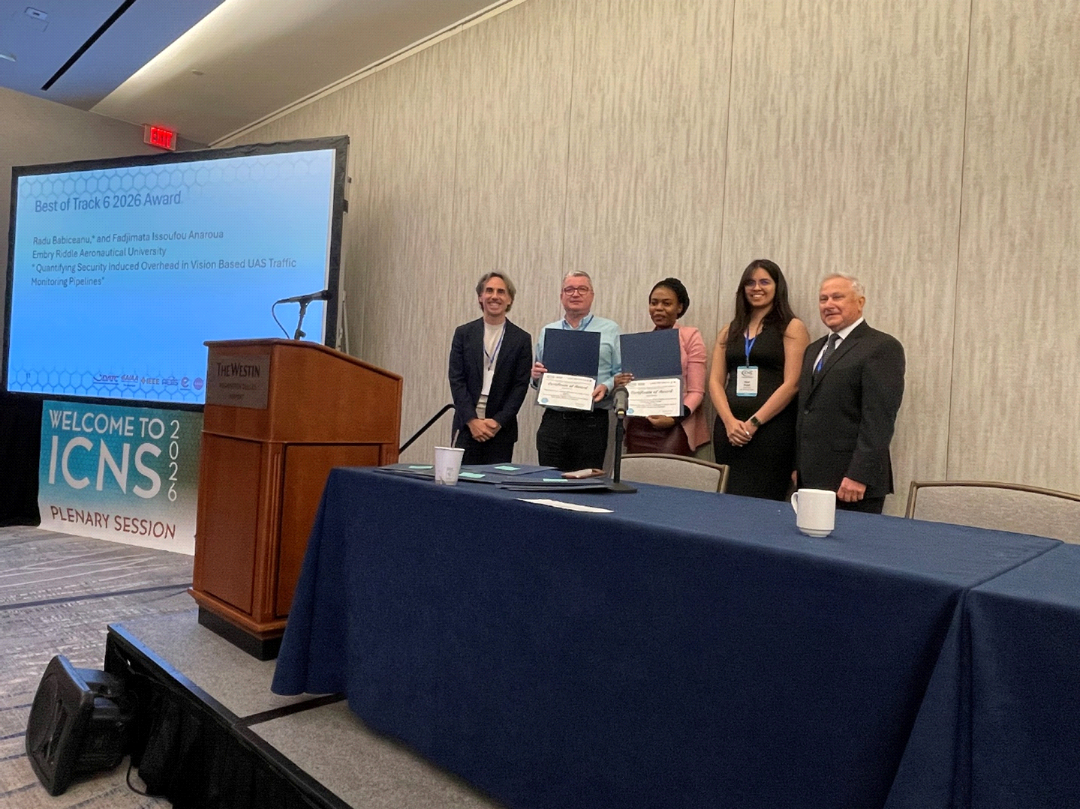 Best of Track 6 award recipients and presenters pose on stage with certificates.