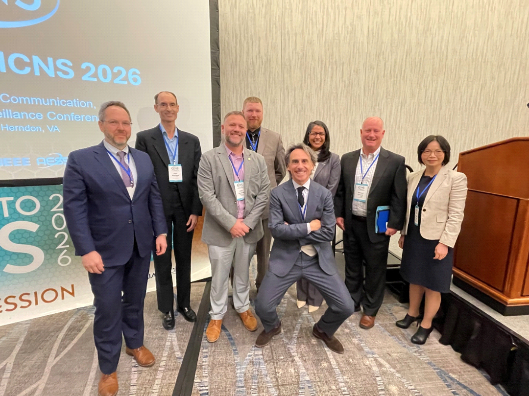 Plenary III participants pose together on stage near the ICNS 2026 session screen.
