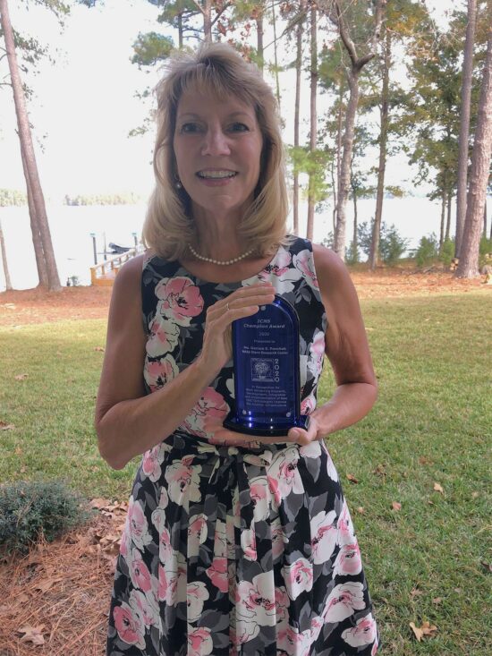 Denise Ponchak holding the 2020 ICNS Champion Award