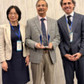 Conference General Co-chair Sherry Yang, ICNS 2026 Champion Award recipient Aloke Roy, and Plenary Program Co-chair Dr. Gabriele Enea.